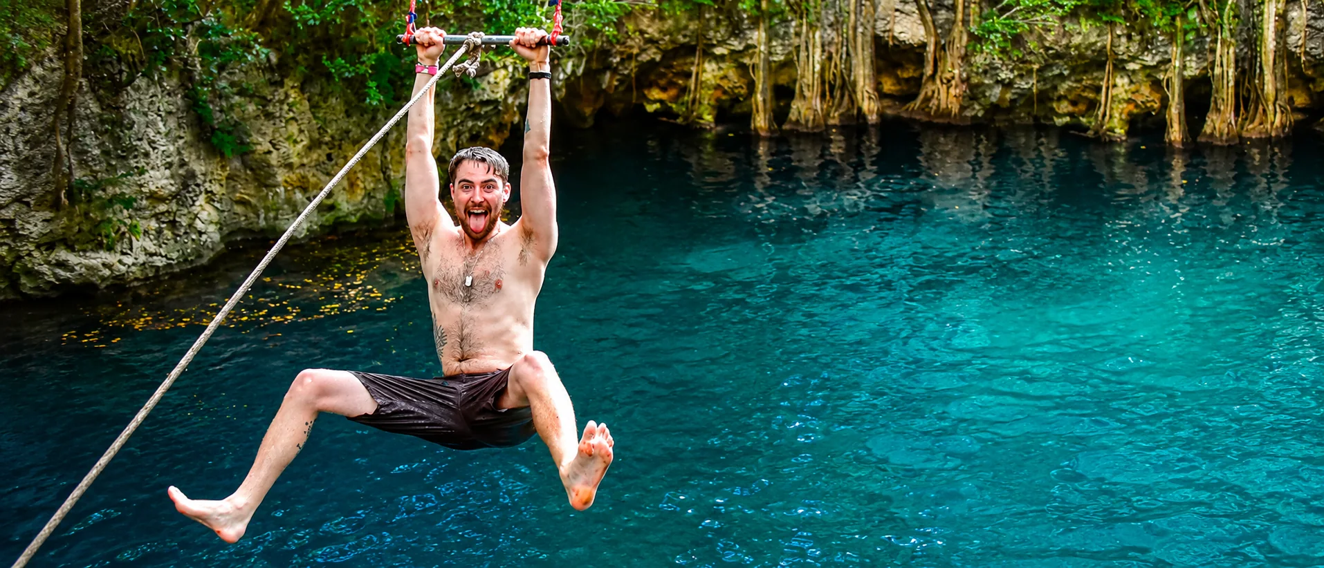 Traveler swinging over a cenote during a Cancun jungle adventure